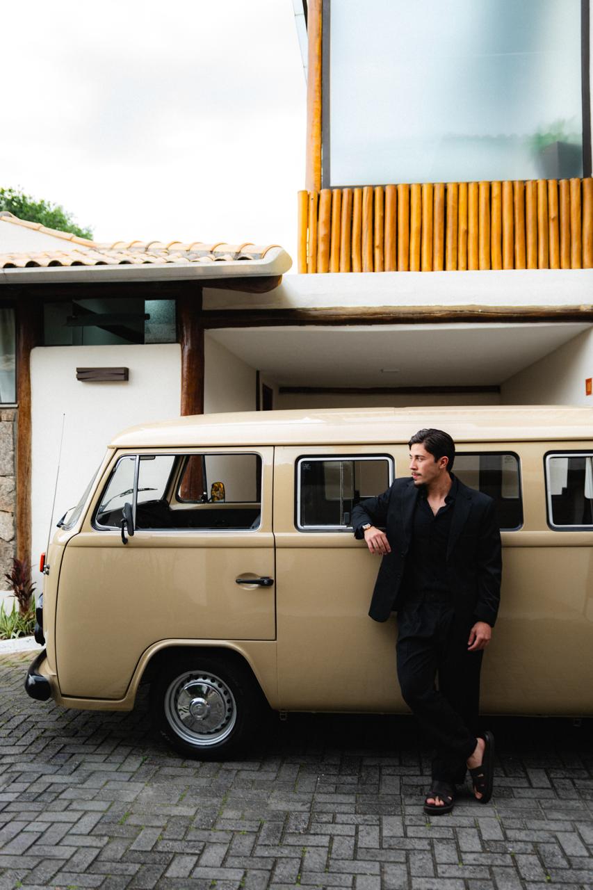 Ryan Alves ao lado de uma Kombi em frente a uma residência